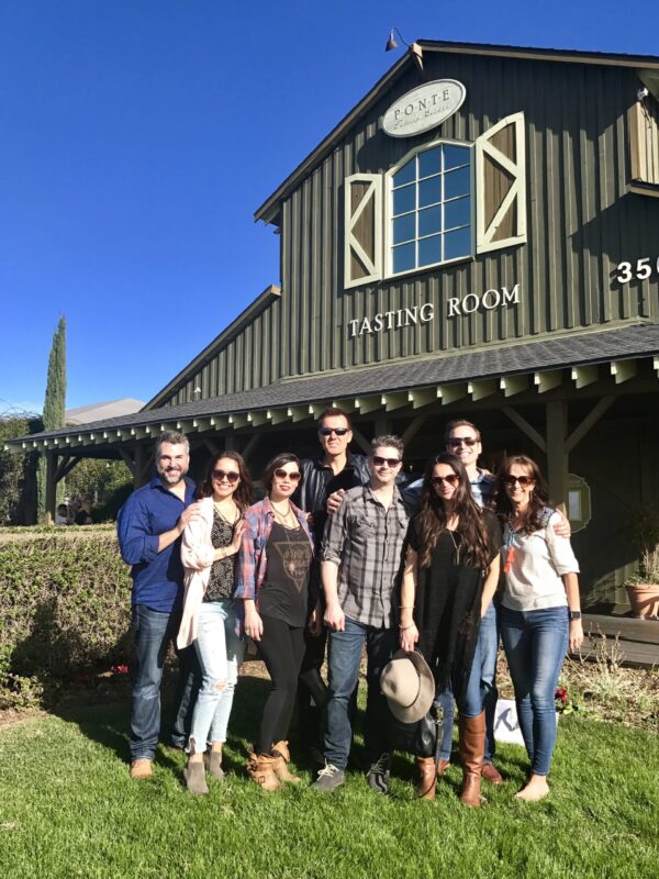 A group of people standing in front of a barn.