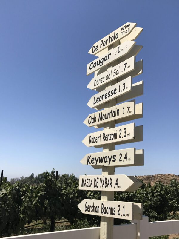 A wooden sign with many different signs on it