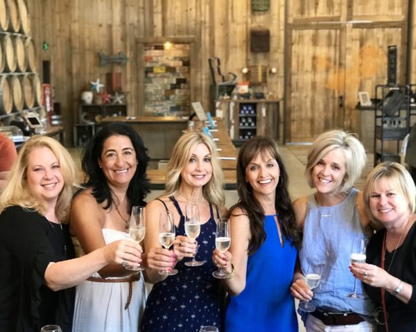 A group of women holding drinks in their hands.