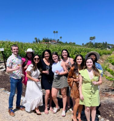 A group of people standing in front of some bushes